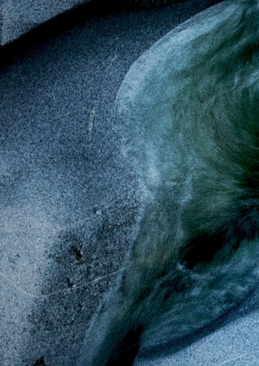 Cropped image of a river rushing over stones