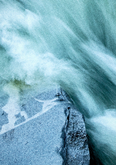Cropped image of a river running over stone 