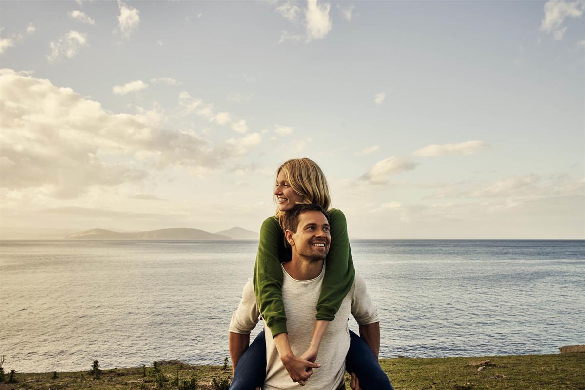 Woman and man on the beach at sunset